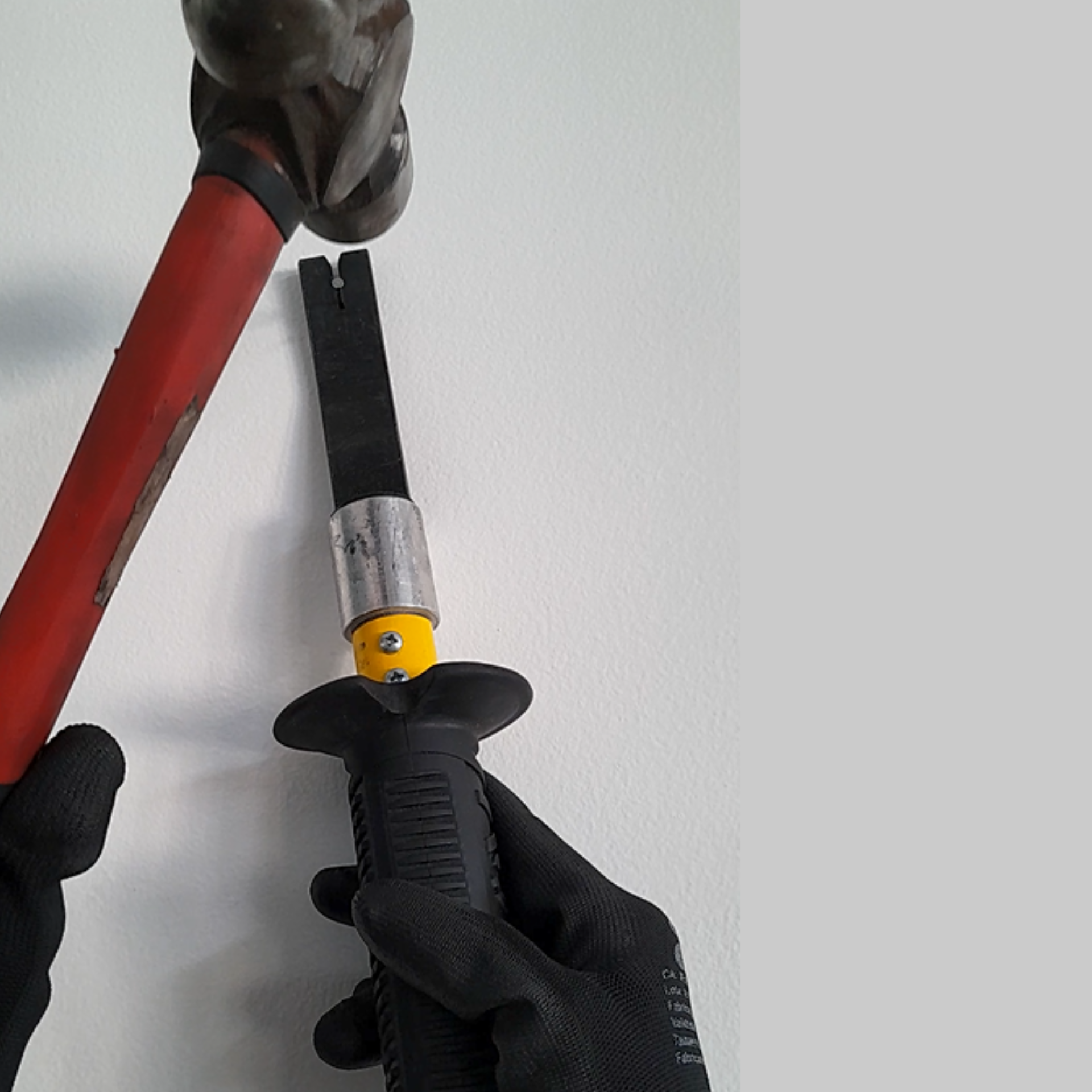 Operador utilizando o Porta-Prego AGMOV para posicionar pregos com segurança, evitando risco de marteladas acidentais nas mãos.