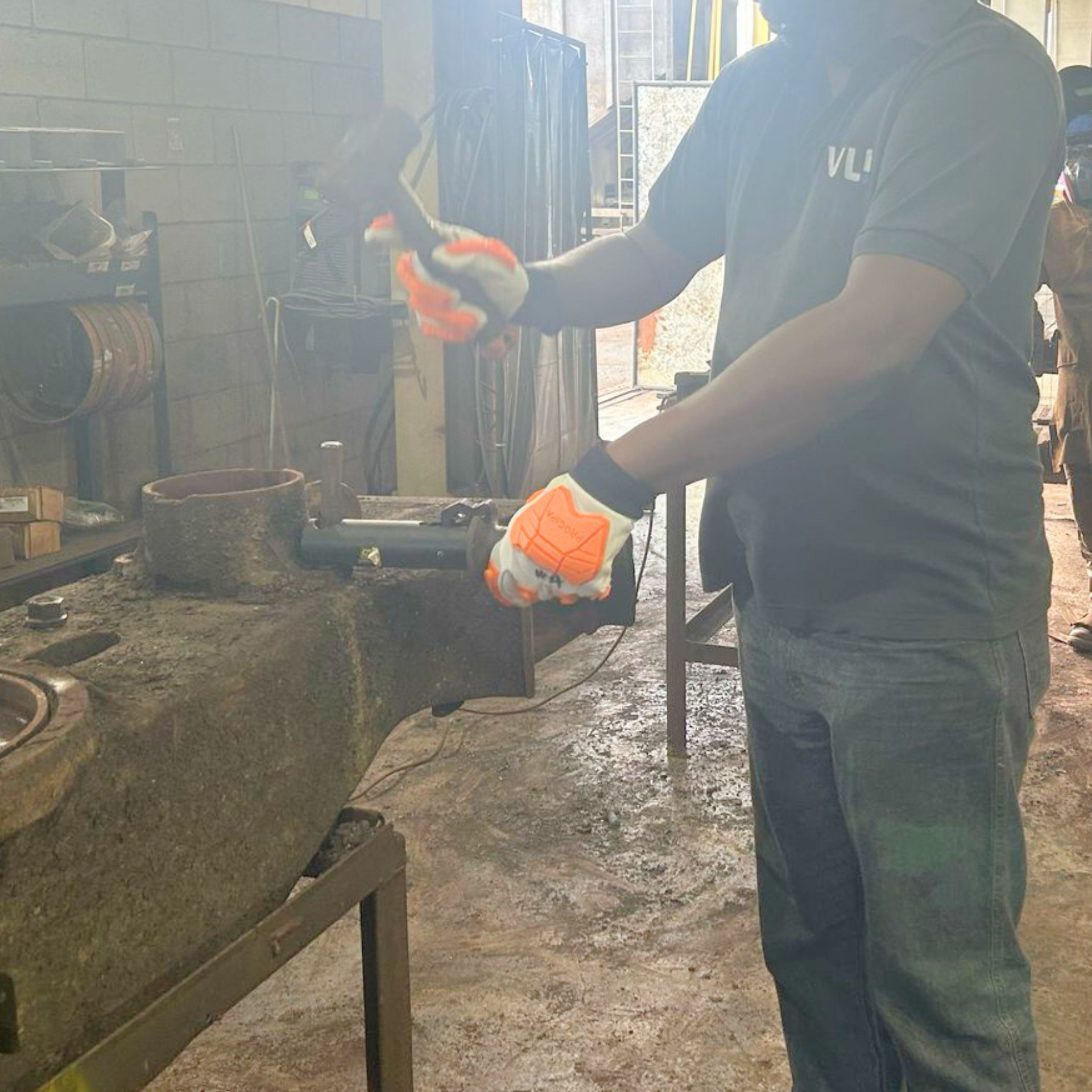 Operador utilizando o Bastão Salvador Automático AGMOV para segurar ferramenta de impacto com fixação por atrito, sem contato direto das mãos.