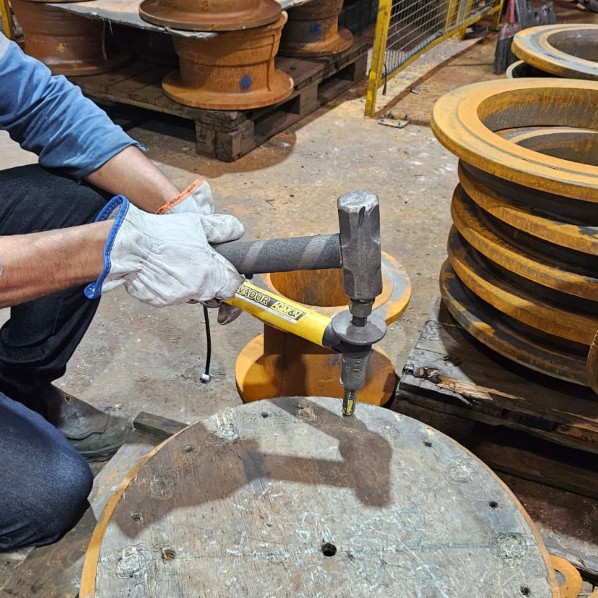 Operador utilizando o Bastão Salvador Standard AGMOV para posicionar e segurar peças com segurança, mantendo as mãos afastadas da zona de risco.