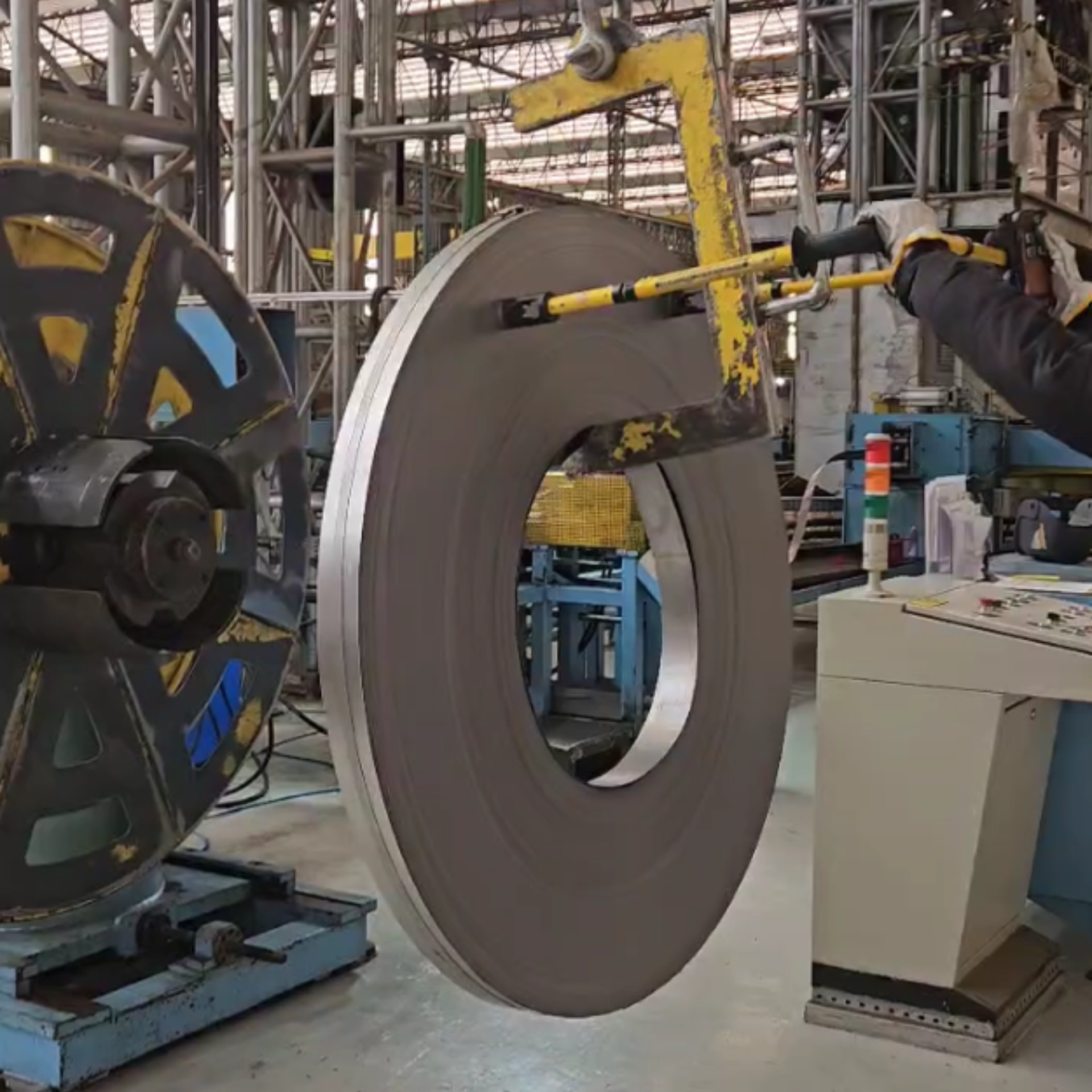 Operador utilizando o Bastão ON/OFF CG Smart AGMOV para direcionar carga içada com segurança e controle, prevenindo riscos de prensamento e cortes.