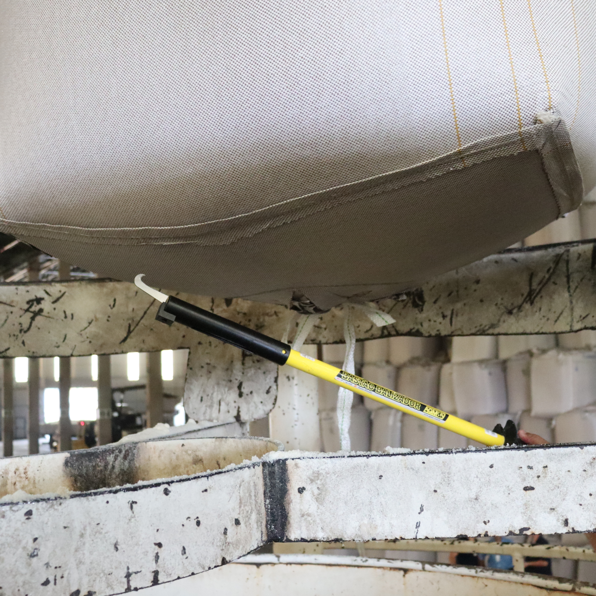 Operador utilizando o Bastão New Fura Bag para perfurar o BAG com segurança, mantendo distância da zona de risco e evitando projeções de partículas.