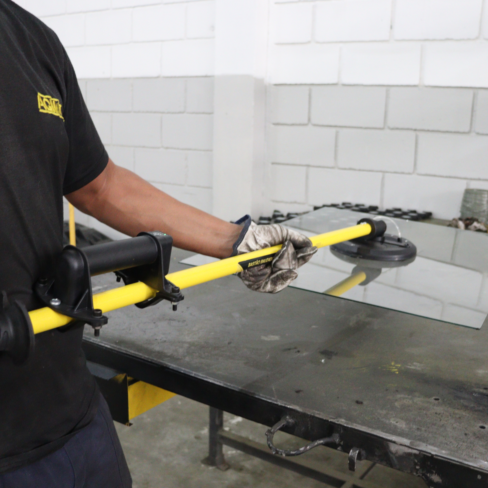 Operador utilizando o Bastão Ventosa Automático AGMOV para movimentar vidros ou chapas metálicas com segurança e precisão.